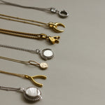Collection of necklaces showing  Personalised gold vermeil, sterling silver initial necklace locket Shown with a beaded chain 