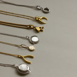 Collection of necklaces showing  Personalised gold vermeil, sterling silver initial necklace locket Shown with a beaded chain 