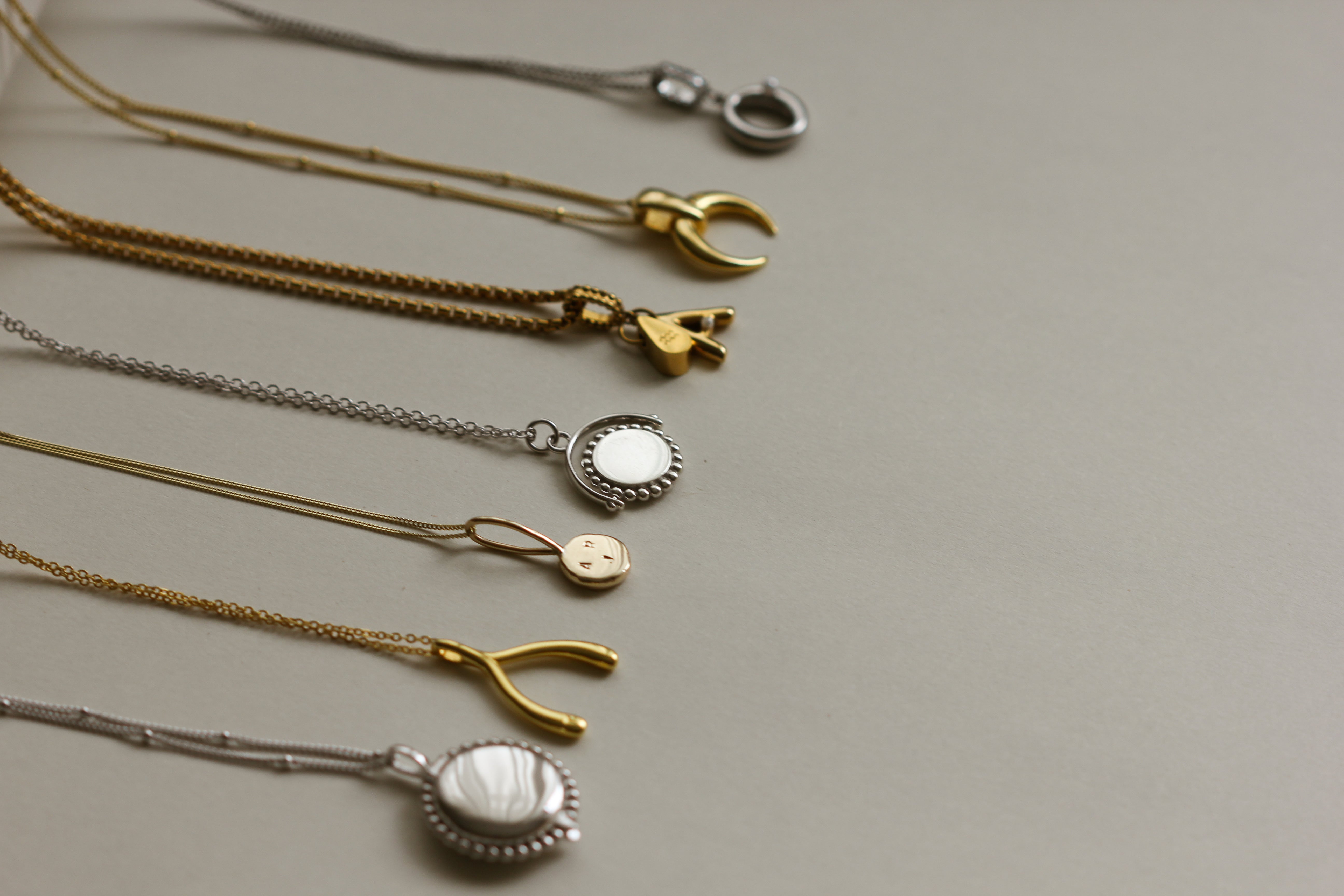 Collection of necklaces showing  Personalised gold vermeil, sterling silver initial necklace locket Shown with a beaded chain 